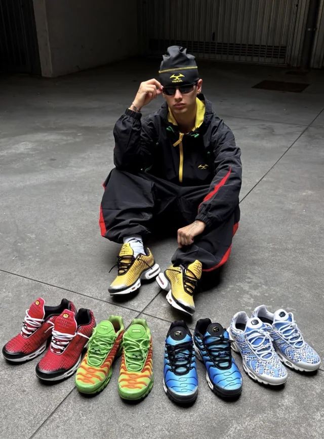 DACI seated beside a selection of colourful trainers