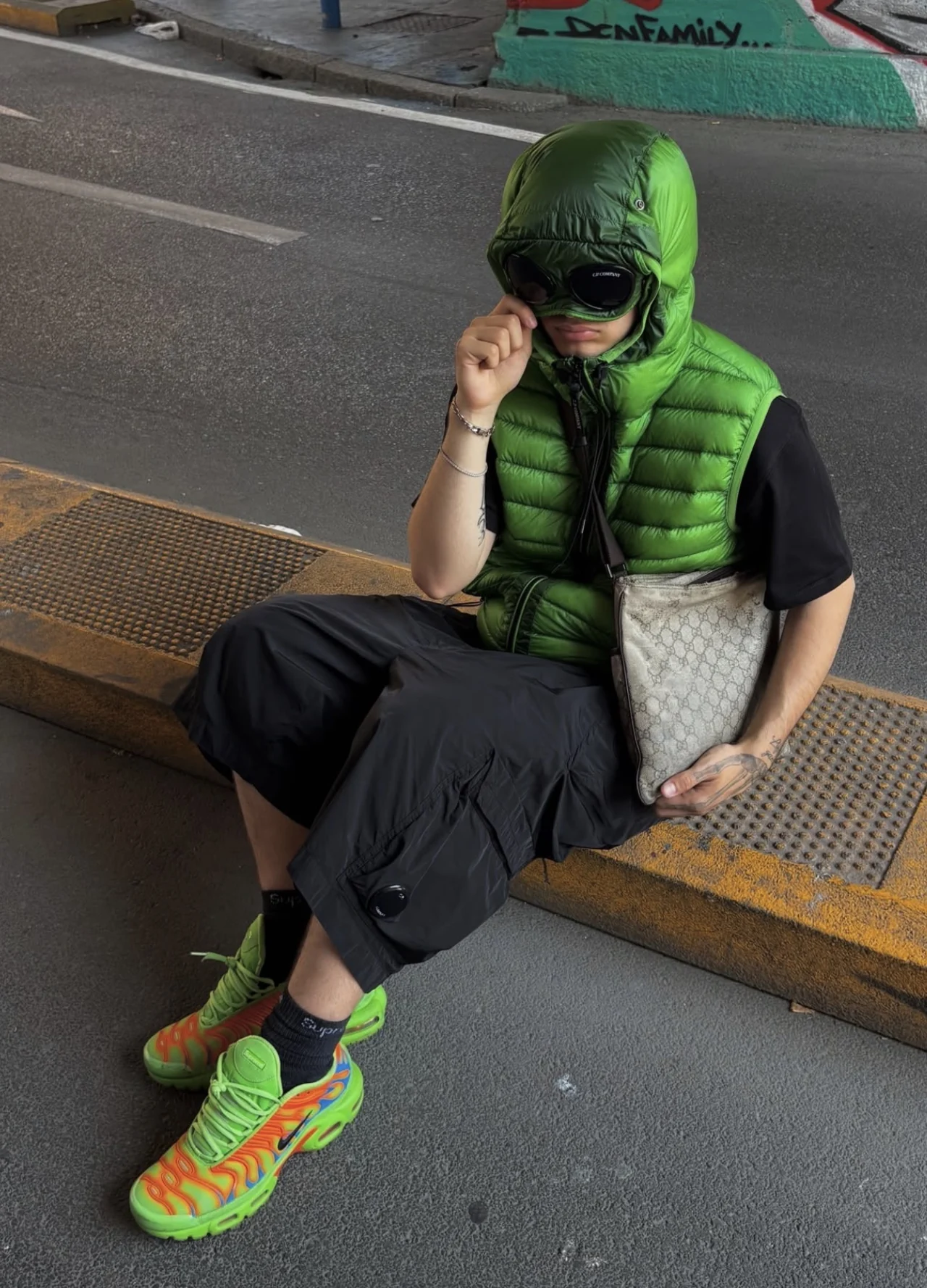 DACI wearing a green hooded gilet and colourful trainers