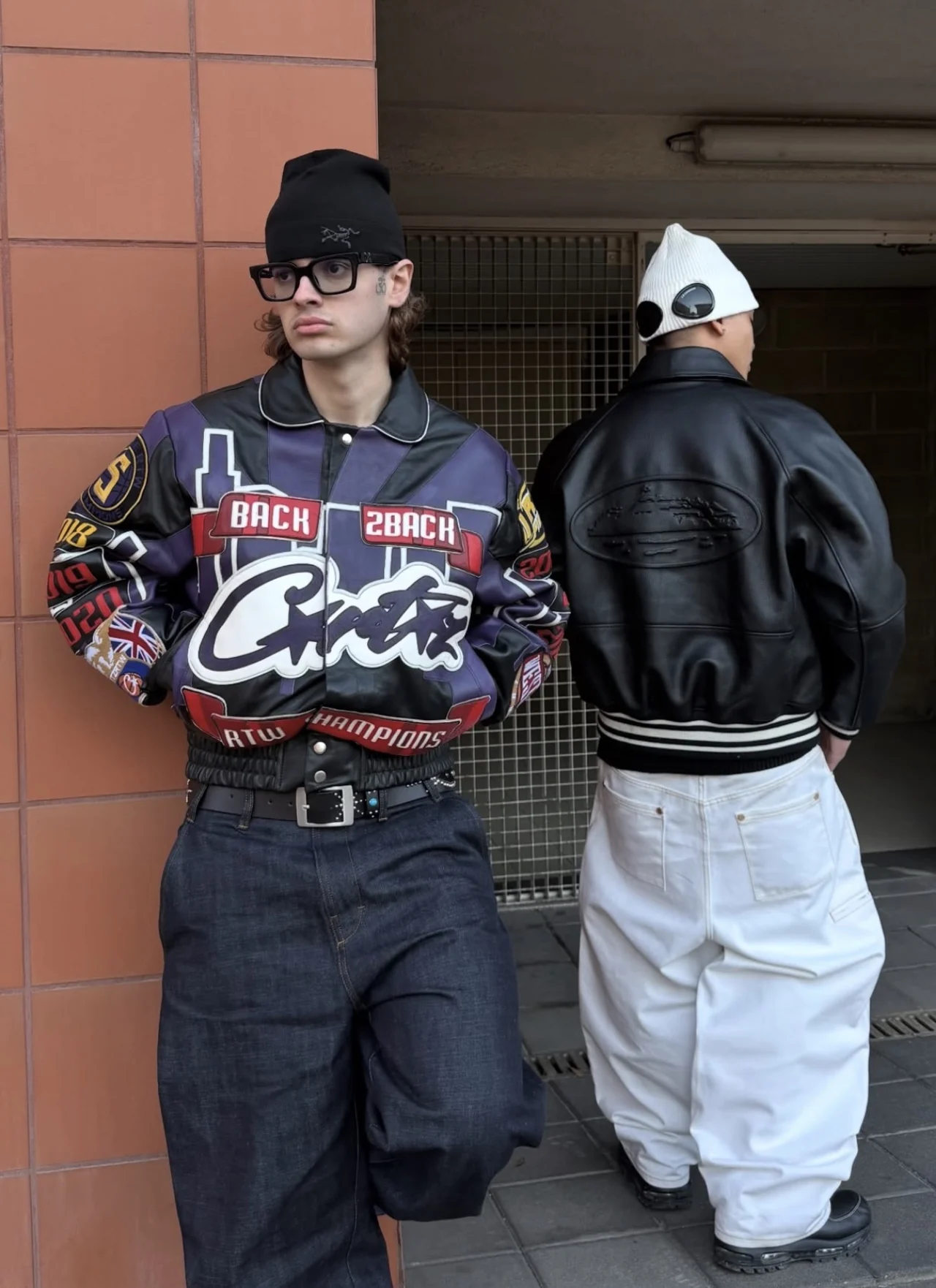Fashion photograph featuring a graphic leather jacket and a black leather jacket