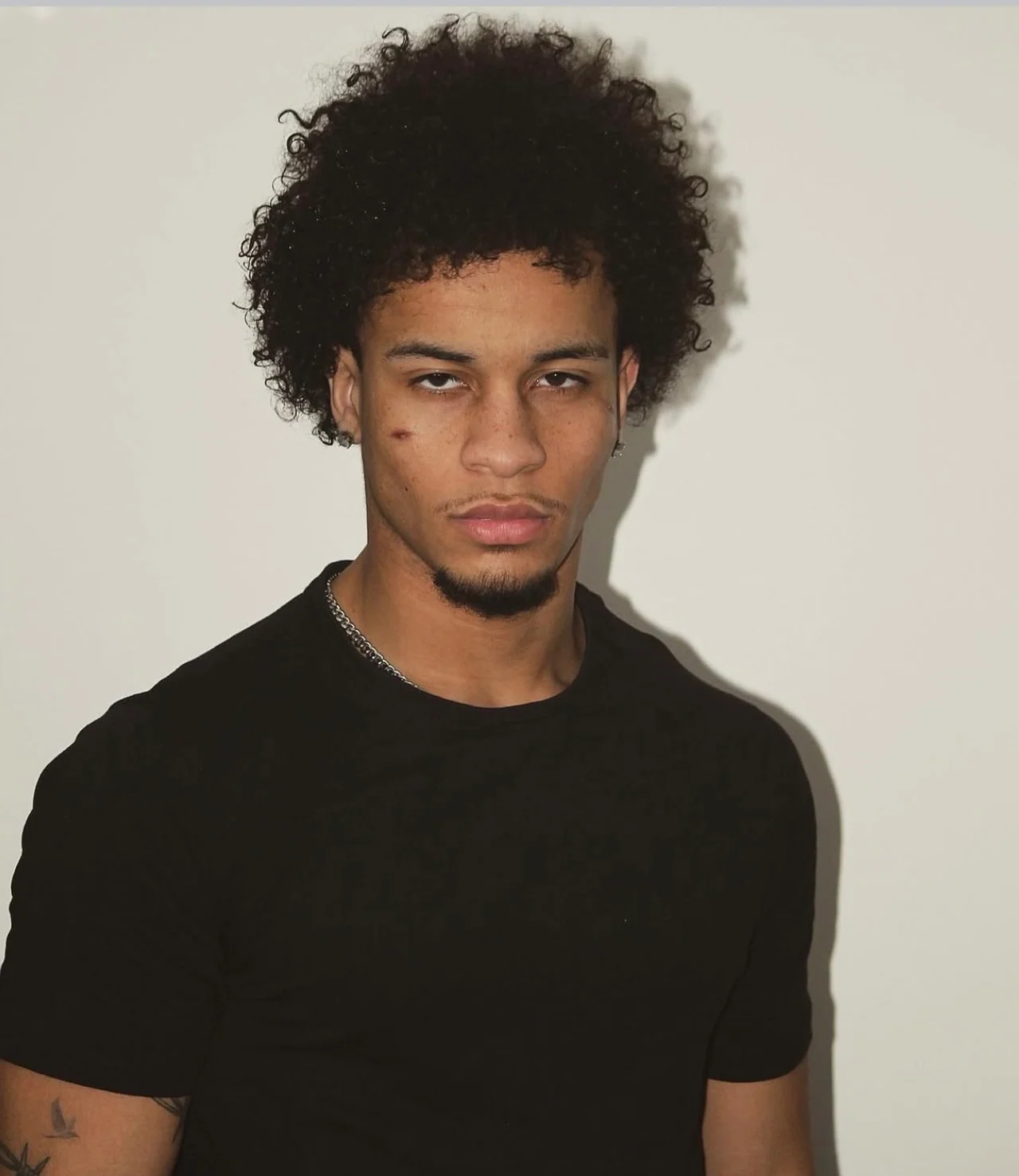 Josh in a plain black T-shirt against a neutral background