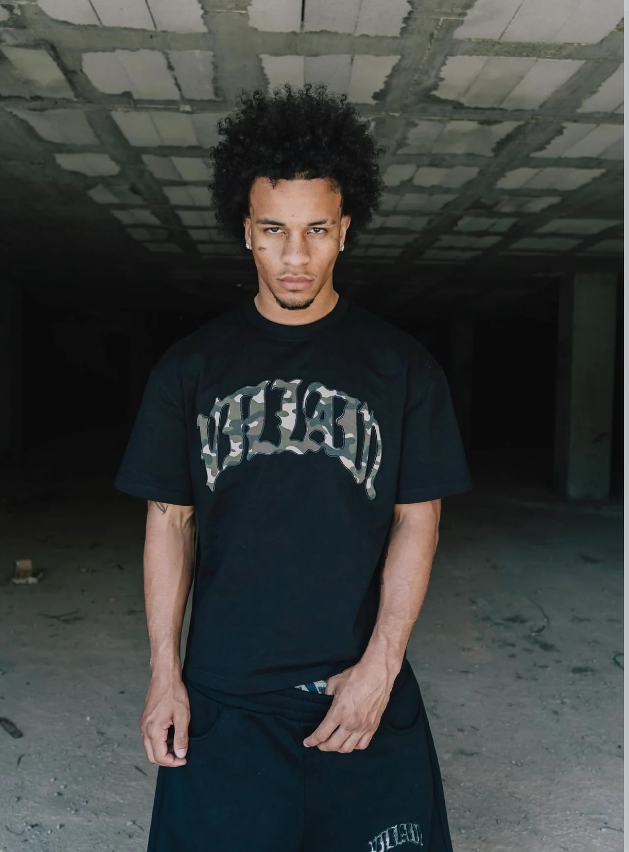 Josh wearing a black graphic T-shirt inside an unfinished building