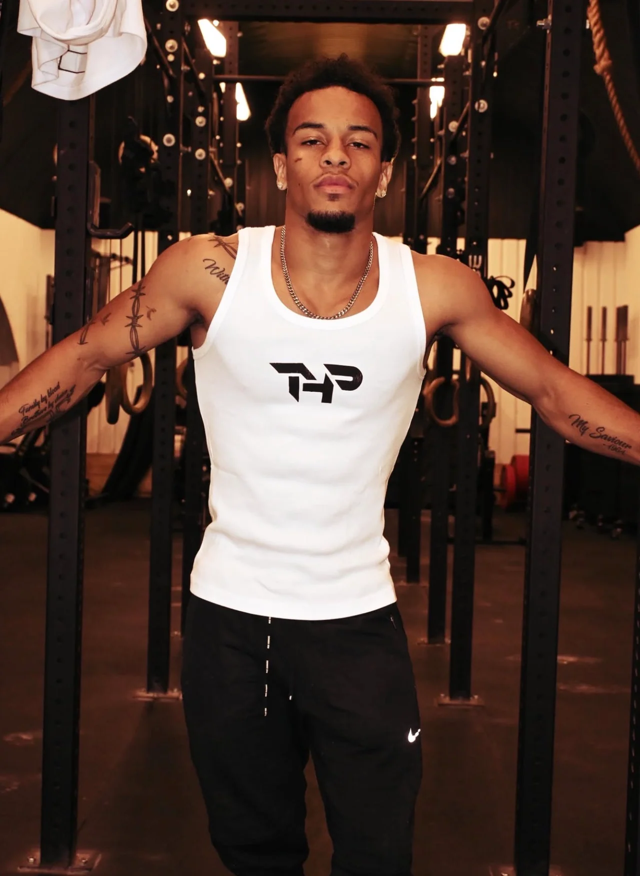 Josh in a white vest at the gym