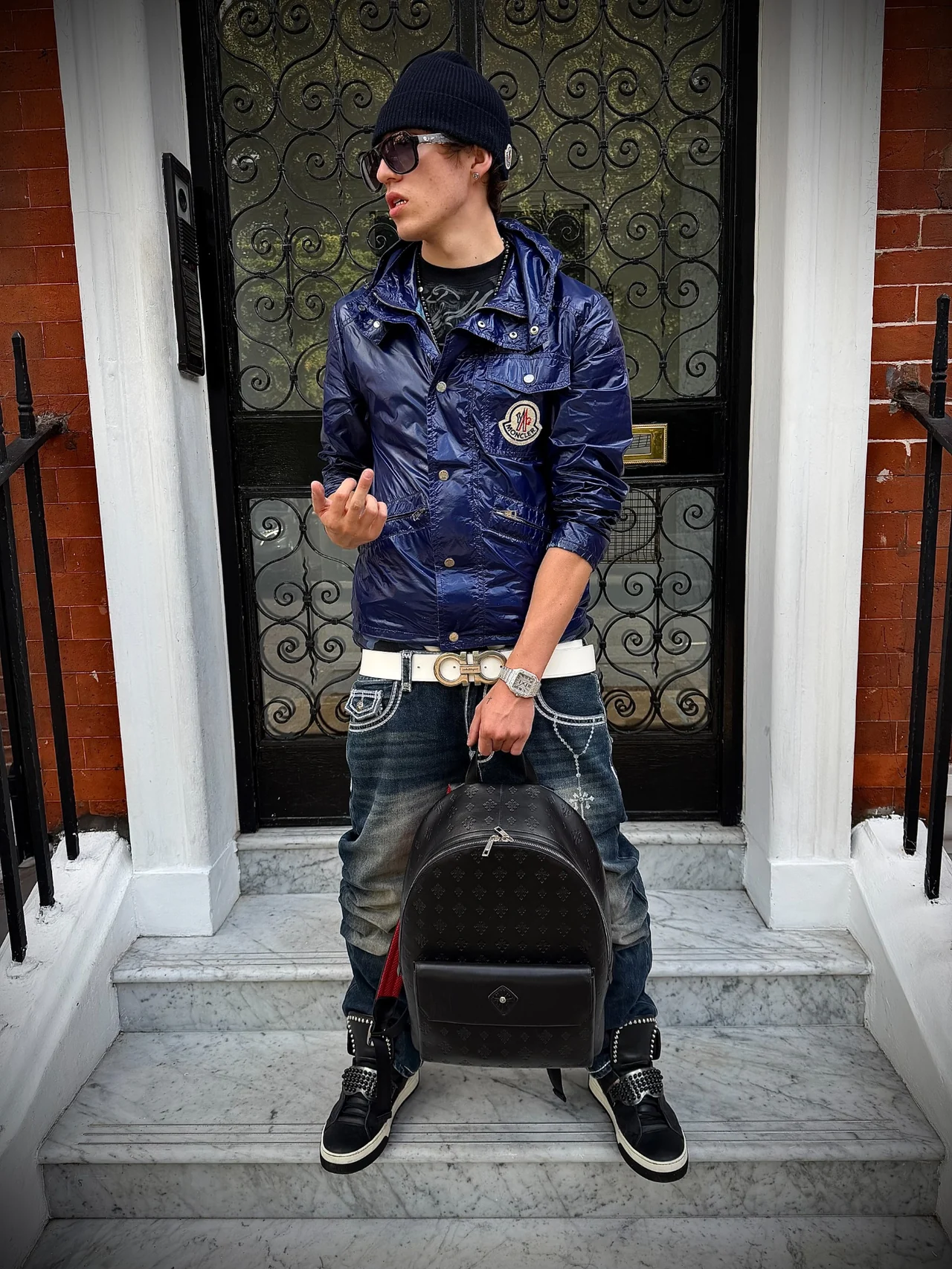 TED wearing a navy Moncler jacket outside a townhouse